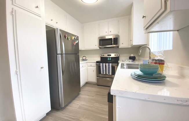 a kitchen with stainless steel appliances and white cabinets