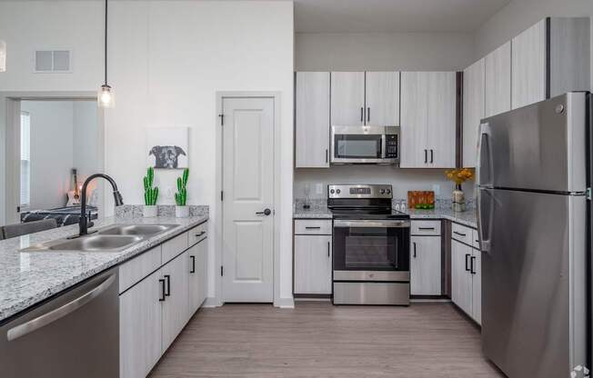 A modern kitchen with stainless steel appliances and white cabinets.