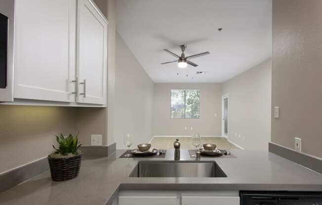 a kitchen with a sink and a ceiling fan