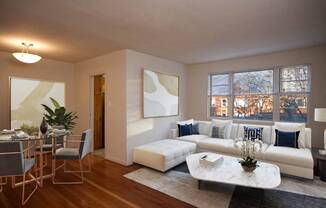 A modern living room with a dining table and a white sofa at battery lane apartments in bethesda