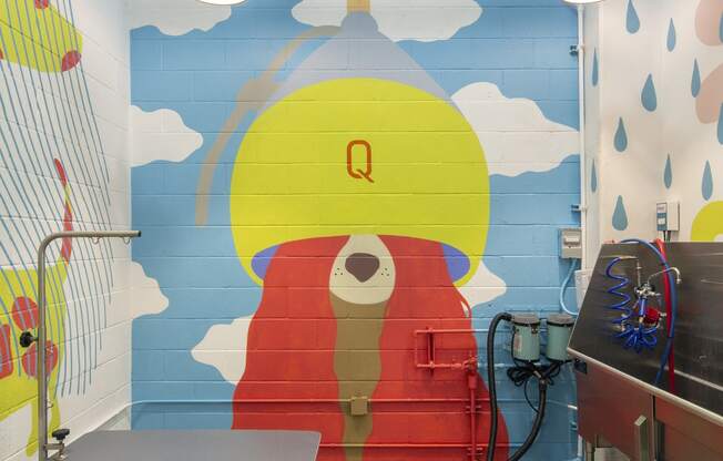 Woodland Hills Pet-Friendly Apartments - The Q Variel Apartments - Dog Wash with a Grooming Table, Washing Tub, Hanging Lights, and a Mural Painted on the Wall