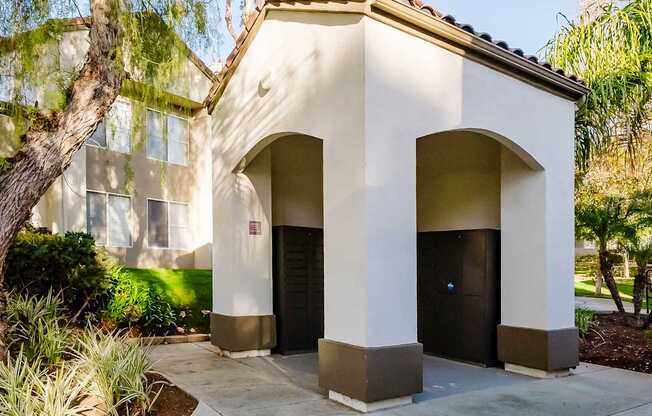 A small building with a black door and a brown roof.