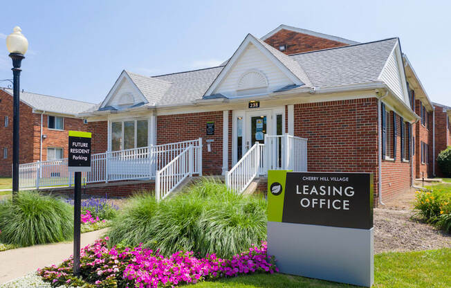 a leasing office sign in front of a brick building