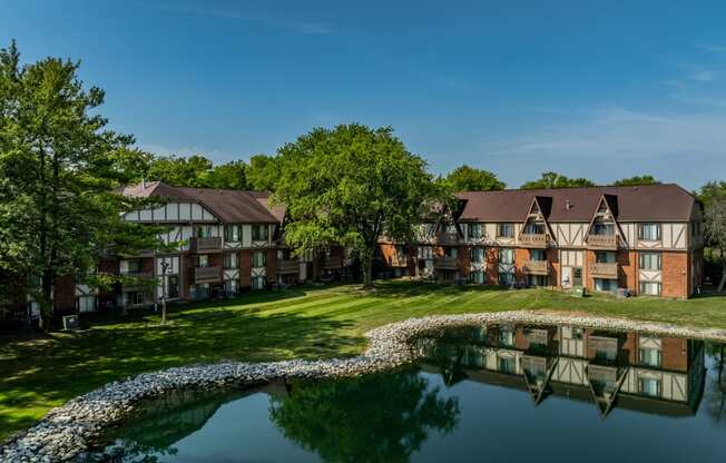 an apartment complex with a pond in front of it