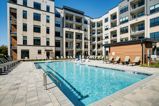 an apartment swimming pool in front of an apartment building