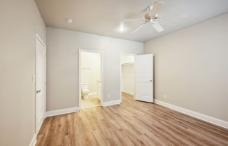 an empty living room with wood flooring and a ceiling fan