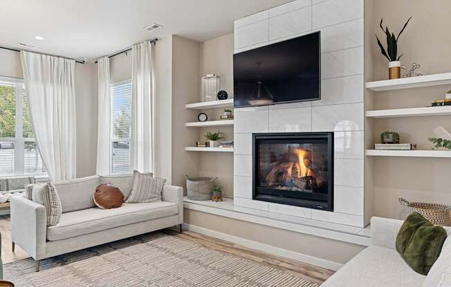 A modern living room with a fireplace and a flat screen TV mounted on the wall.