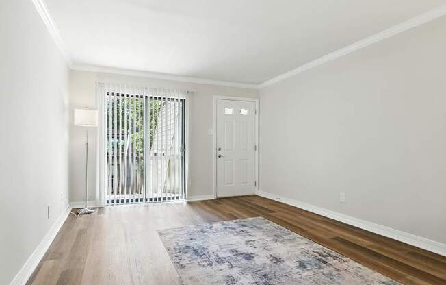 A room with a white door and a window with a white curtain.