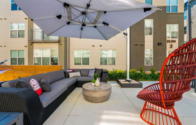 a patio with a couch and chairs and an umbrella at Mockingbird Flats, Dallas, TX, 75206