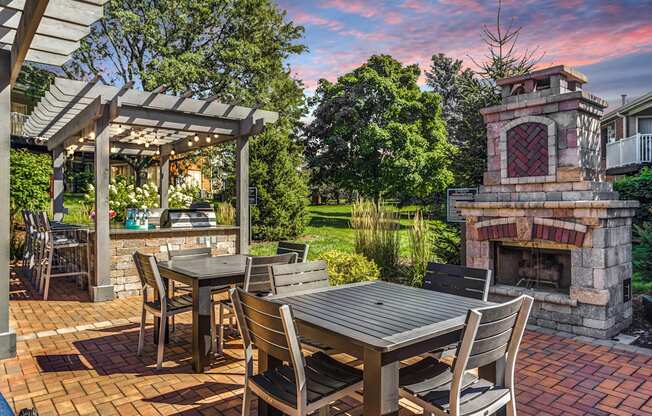 Apartments in Geneva, IL for Rent- Ashford at Geneva- A patio with a table and chairs and a fireplace.