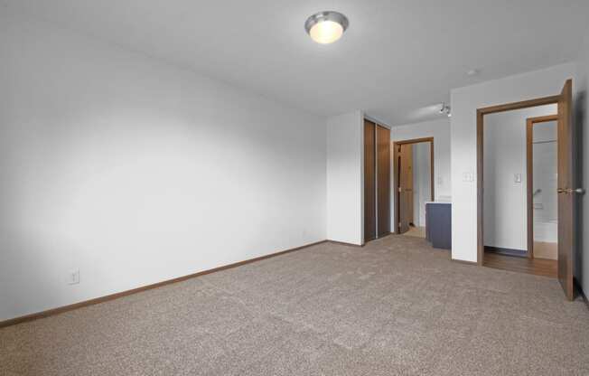 a bedroom with white walls and a carpeted floor