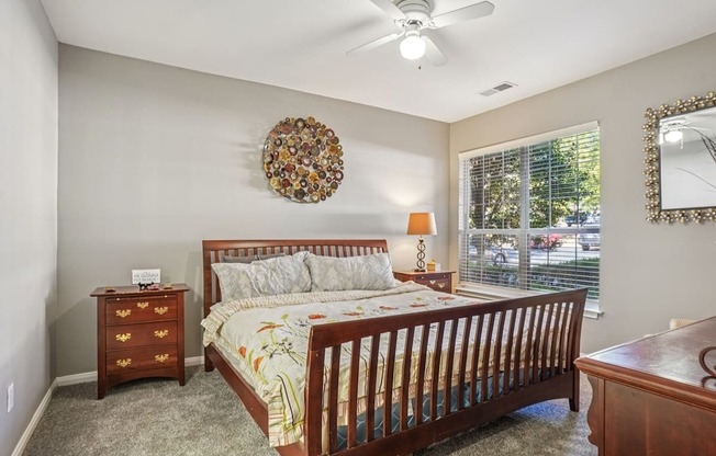 A bedroom with a bed, dresser, and mirror.