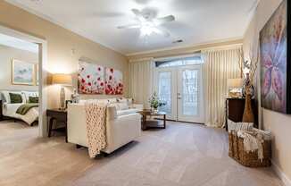 A living room with a white couch and a ceiling fan.