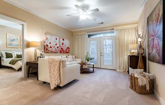 A living room with a white couch and a ceiling fan.