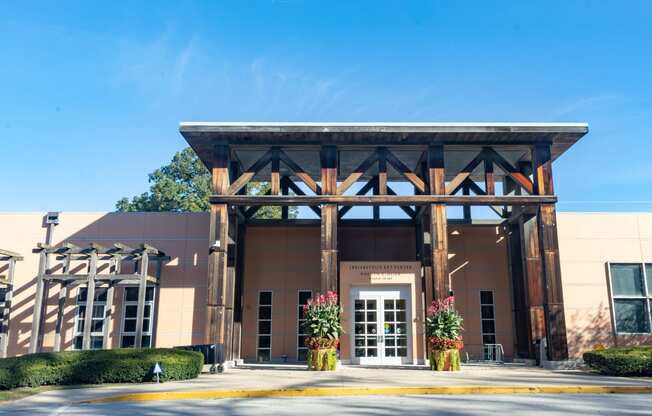 the front entrance of a building with a brown facade and pillars