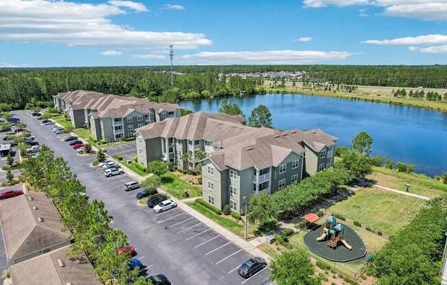 A view of a parking lot with cars and apartment buildings.