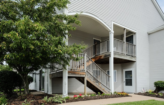 grey siding with mature trees, landscape, and private entrances at regency apartments in Bettendorf Iowa