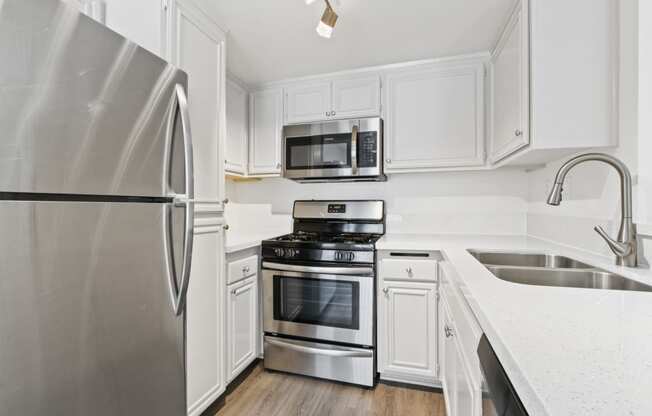 a kitchen with stainless steel appliances and white cabinets