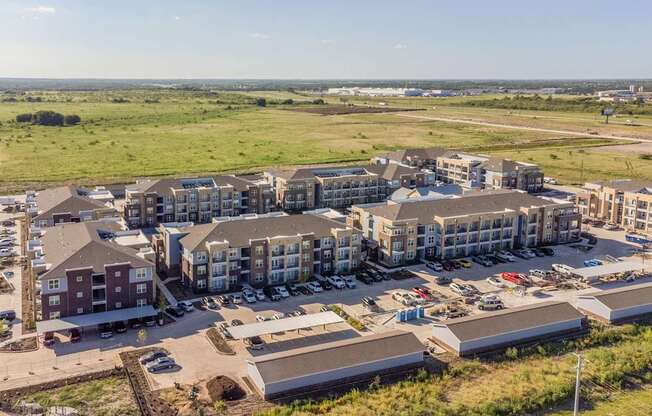 an aerial view of an apartment complex with a field in the background