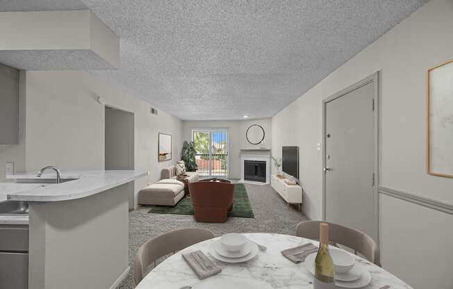 A dining table set for two with a bottle of wine on it.