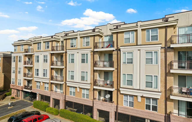 An aerial view of Ten05 West Trade Apartments with hedges out front and cars parked underneath.