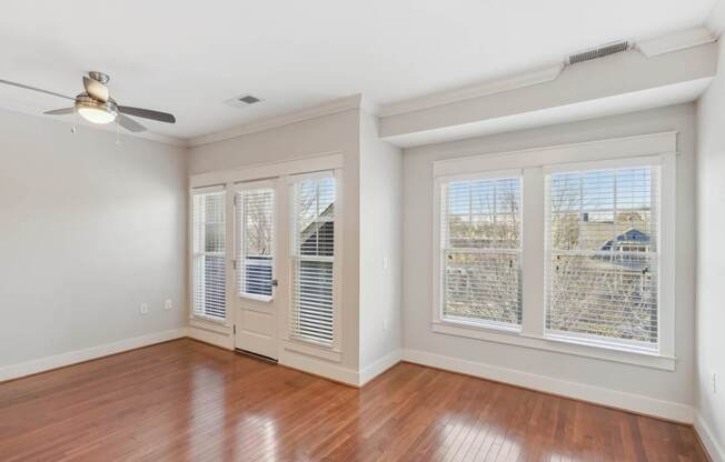 A room with a ceiling fan and sliding glass doors.