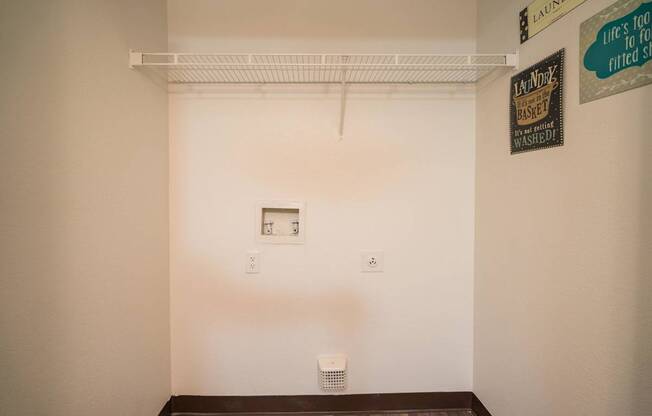 A laundry sign is on the wall above a white dryer at Sterling Point Apartment Homes, Arizona