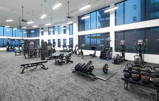 A gym with a variety of equipment including weights and cardio machines.