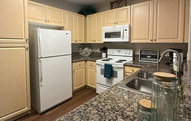 a kitchen with white appliances and granite counter tops