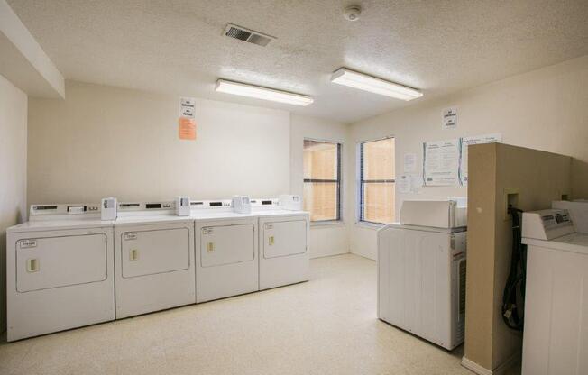 A laundry room with washers and dryers.