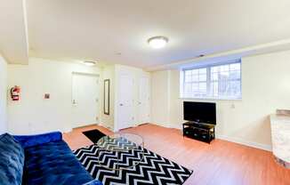 living area with sofa, credenza, tv, coffee table and window at park vista apartments in washington dc
