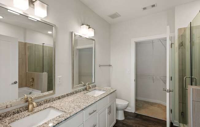 a bathroom with two sinks and a shower and a toilet