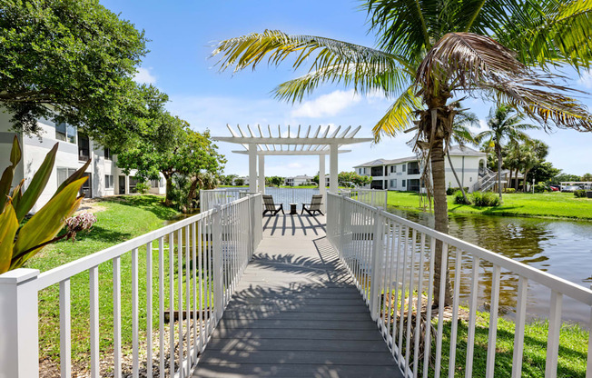 a white bridge over a body of water with palm trees