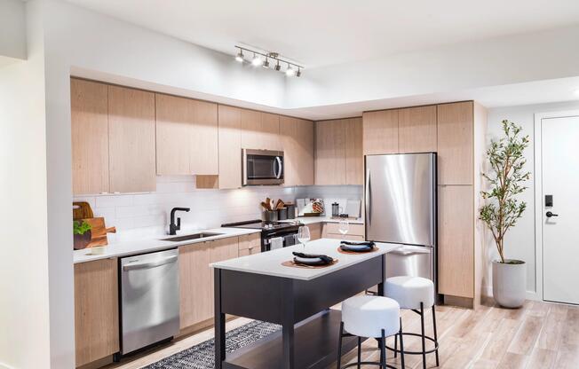 Warm wood cabinetry, clean-lined finishes, and a functional island create a kitchen designed for everyday ease at Modera Aventura.