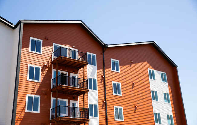 a large building with balconies and a blue sky