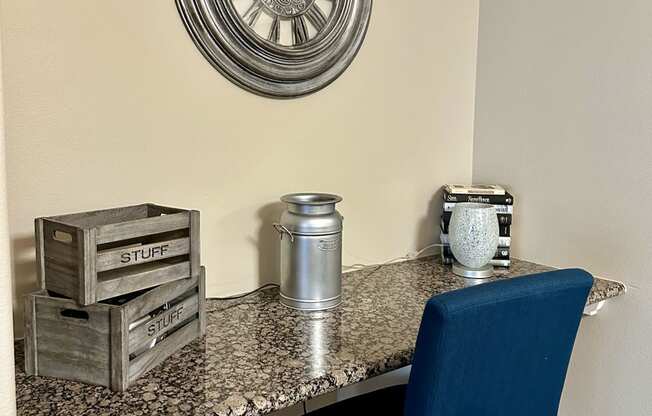 a desk with a blue chair and a clock on the wall