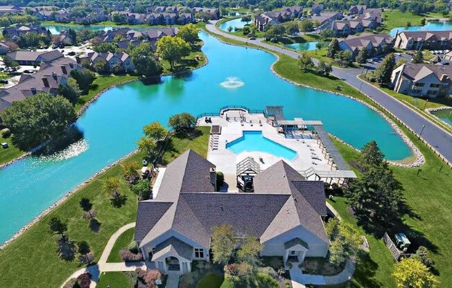an aerial view of a house with a swimming pool and a lake