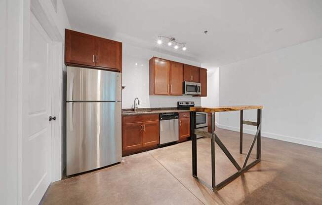 A kitchen with a wooden table and stainless steel appliances at River Mill Lofts & Skyloft in Asheville, 28803