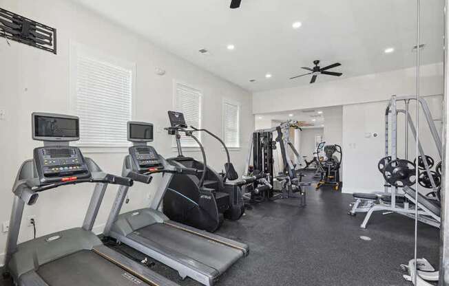 A spacious home gym with treadmills, elliptical machines, and other exercise equipment.
