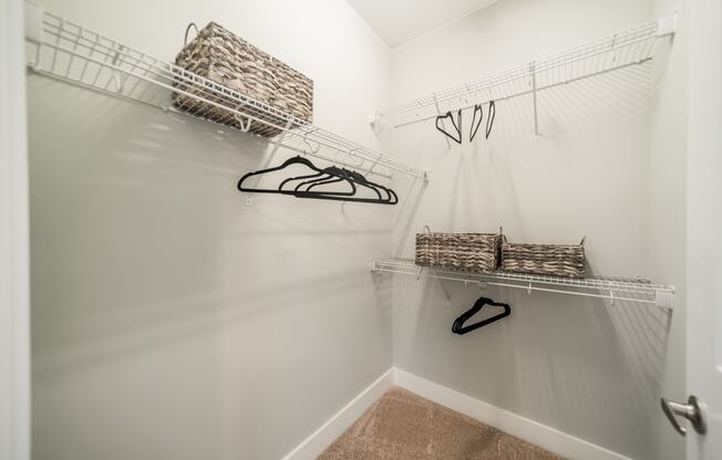 a walk in closet with a pair of shoes and baskets