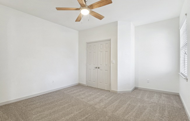 an empty living room with white walls and a ceiling fan at The Legends at Eagle Mountain Lake, Texas, 76179