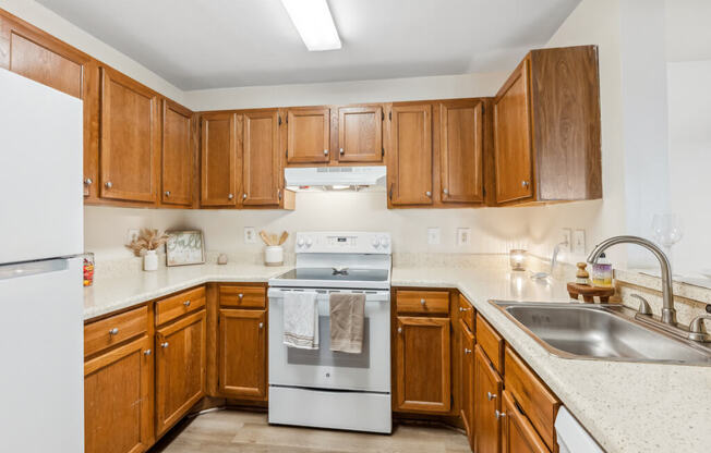 a kitchen with wooden cabinets and white appliances