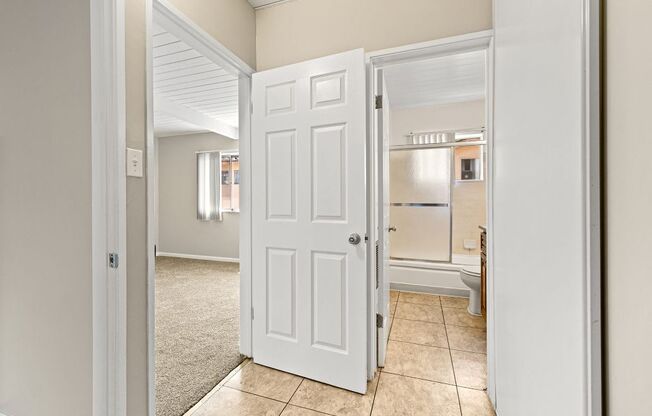 A white door is open to a kitchen.