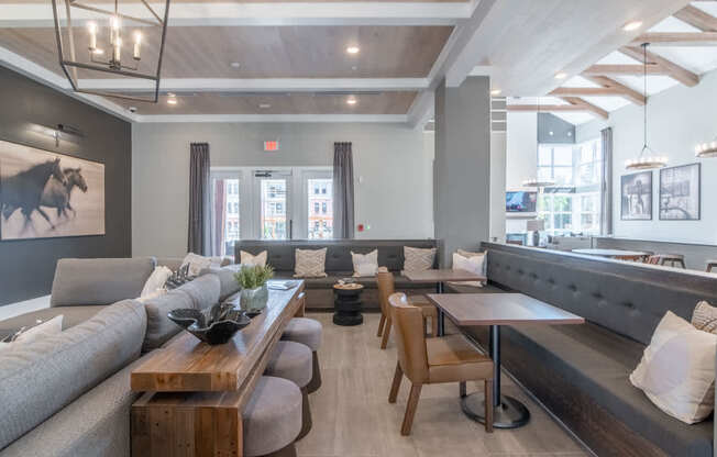 a living room with couches tables and chairs and a bar