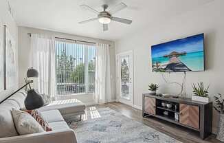 A living room with a flat screen TV mounted on the wall.