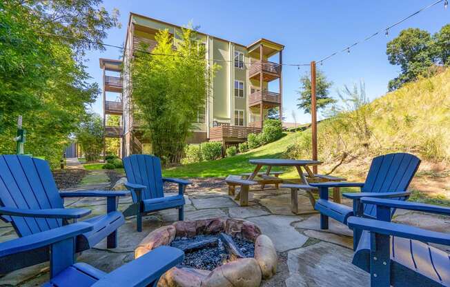 fire pit and chairs on a patio with a building in the background at River Mill Lofts & Skyloft, Asheville, NC 28803