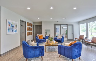 a living room with blue chairs and a coffee table