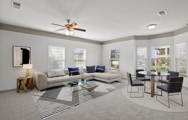 a living room with a couch a table and a ceiling fan