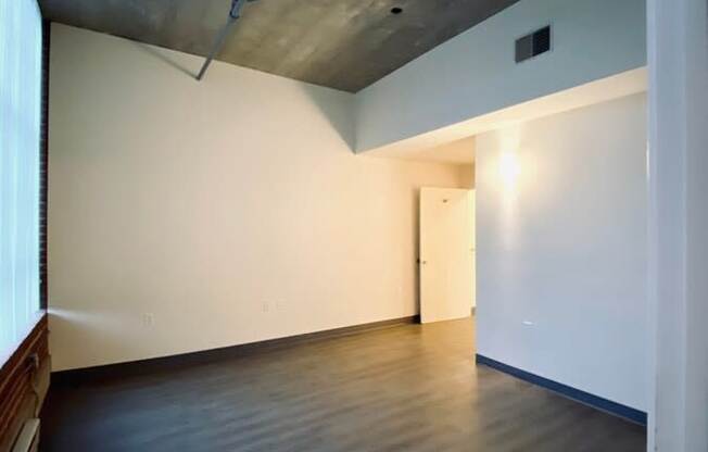 A room with a wooden floor and a white wall.