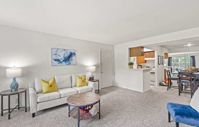 a living room with a white couch and yellow pillows at Pebblebrook, Kansas